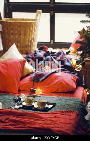 Decorazioni natalizie e tazza da tè sul letto. Primo piano Foto Stock