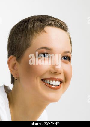 Ritratto di una giovane donna con i capelli corti su sfondo bianco Foto Stock