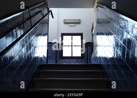 Scala in pietra con parete piastrellata e finestra chiusa sullo sfondo a Madrid, Spagna Foto Stock