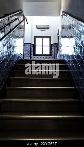 Scala in pietra con parete piastrellata e finestra chiusa sullo sfondo a Madrid, Spagna Foto Stock