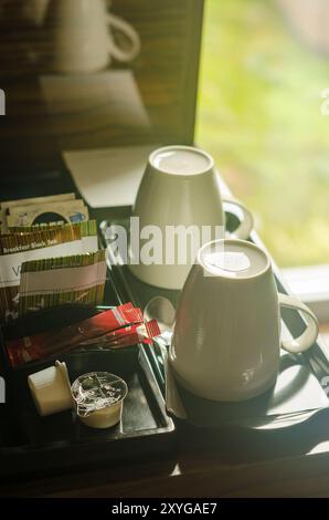 due tazze bianche, alcune bustine di tè e caffè sul tavolo da caffè in camera d'albergo. Foto di alta qualità Foto Stock