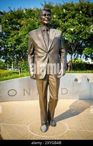 ARLINGTON, Virginia - la statua di Ronald Reagan all'aeroporto nazionale Ronald Reagan di Washington (DCA) commemora il 40° presidente degli Stati Uniti. Creata dal famoso scultore Paul Moore, questa statua in bronzo si erge in modo prominente all'ingresso dell'aeroporto, simboleggiando l'eredità duratura di Reagan e i contributi all'aviazione e alla storia americana. Situato ad Arlington, Virginia, l'aeroporto funge da porta vitale per la capitale della nazione, riflettendo sia il suo significato storico che l'importanza moderna. Foto Stock