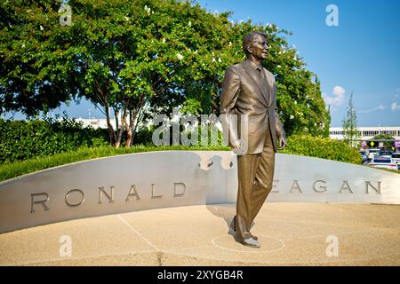 Statua di Ronald Reagan Aeroporto DCA Arlington Virginia // ARLINGTON, Virginia — la statua di Ronald Reagan presso l'Aeroporto Nazionale Ronald Reagan di Washington (DCA) commemora il 40° Presidente degli Stati Uniti. Creata dal famoso scultore Paul Moore, questa statua in bronzo si erge in modo prominente all'ingresso dell'aeroporto, simboleggiando l'eredità duratura di Reagan e i contributi all'aviazione e alla storia americana. Situato ad Arlington, Virginia, l'aeroporto funge da porta vitale per la capitale della nazione, riflettendo sia il suo significato storico che l'importanza moderna. Foto Stock