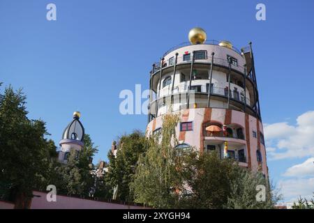 Magdeburgo, Germania 08-26-2024 Cittadella verde, torre della casa di Hundertwasser con elementi dorati Foto Stock