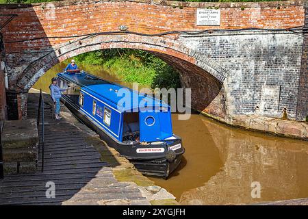 Il motoscafo del canale si avvicina a Bunbury, chiusa a doppia scala, sul canale Shropshire Union, Cheshire Foto Stock