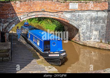 Il motoscafo del canale si avvicina a Bunbury, chiusa a doppia scala, sul canale Shropshire Union, Cheshire Foto Stock