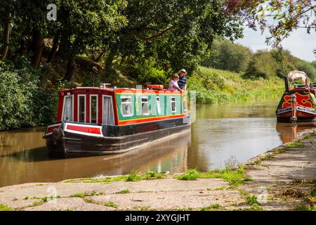 Il motoscafo del canale si avvicina a Bunbury, chiusa a doppia scala, sul canale Shropshire Union, Cheshire Foto Stock