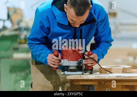 Primo piano del lavoratore tagliando e planando con cura pezzi di legno per mobili nell'industria del legno Foto Stock