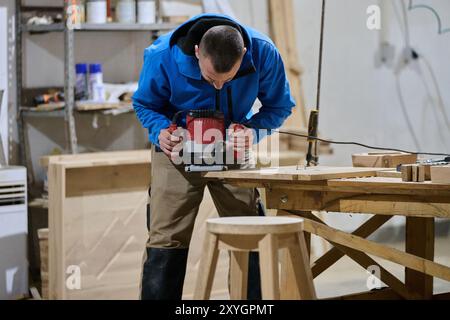 Primo piano del lavoratore tagliando e planando con cura pezzi di legno per mobili nell'industria del legno Foto Stock