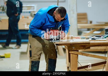 Primo piano del lavoratore tagliando e planando con cura pezzi di legno per mobili nell'industria del legno Foto Stock