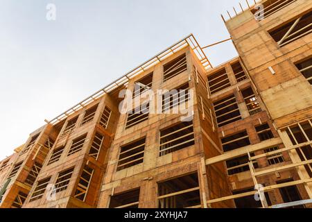 Nuova costruzione residenziale che si inquadra contro un cielo blu. Costruzione di tetti. Costruzione in legno. Incorniciatura di una nuova casa in legno in costruzione Foto Stock