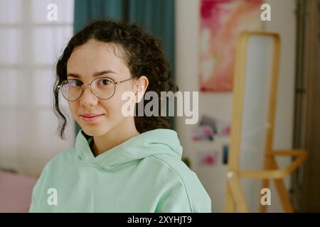 Ritratto di una giovane donna che indossa gli occhiali e sorride dolcemente Foto Stock