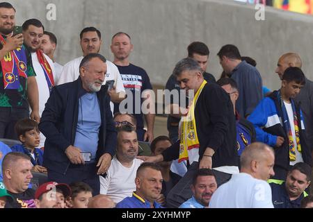 Bucarest, Romania. 29 agosto 2024: Marcel Ciolacu (R), presidente del Partito Socialdemocratico (PSD) e primo ministro rumeno, e Paul Stanescu (L), segretario generale del PSD, in tribuna durante la UEFA Europa League, play-off partita di calcio di 2a tappa tra FCSB e LASK, allo stadio Steaua, a Bucarest. Crediti: Lucian Alecu/Alamy Live News Foto Stock