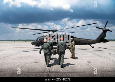 Gli studenti di medicina di volo del Naval Aerospace Medical Institute (NAMI) praticano pazienti a "carico caldo" su un elicottero attivo UH-60 Blackhawk, 22 agosto. NAMI è un distaccamento del Navy Medicine Operational Training Command (NMOTC) le cui strutture supportano programmi di addestramento in aviazione, guerra di superficie e sottomarina, forze di spedizione e operazioni speciali, forniscono addestramento medico per la Marina, altre forze armate statunitensi e nazioni alleate. (Foto della Marina degli Stati Uniti di Russell Lindsey SW/AW, specialista della comunicazione di massa di 1a classe) Foto Stock