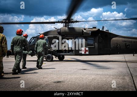 Gli studenti di medicina di volo del Naval Aerospace Medical Institute (NAMI) esercitano pazienti a "carico caldo" su un elicottero attivo come parte di un esercizio congiunto di malattia da decompressione iperbarica militare/marina, agosto 22. NAMI è un distaccamento del Navy Medicine Operational Training Command (NMOTC) le cui strutture supportano programmi di addestramento in aviazione, guerra di superficie e sottomarina, forze di spedizione e operazioni speciali, forniscono addestramento medico per la Marina, altre forze armate statunitensi e nazioni alleate. (Foto della Marina degli Stati Uniti di Russell Lindsey SW/AW, specialista della comunicazione di massa di 1a classe) Foto Stock