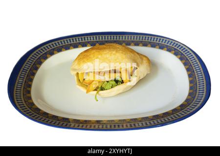 Un delizioso panino di pita ripieno di patatine fritte su un piatto isolato su sfondo bianco, un tipico spuntino medio-orientale o un pasto Foto Stock