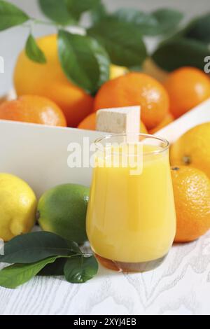 Agrumi freschi nella scatola di legno e succhi di frutta Foto Stock