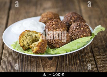 Falafel fatto in casa (primo piano, messa a fuoco selettiva) su sfondo in legno Foto Stock