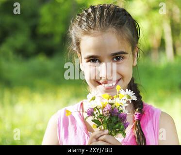 Close up ritratto di poco sorridente ragazza con molla bouquet di fiori Foto Stock