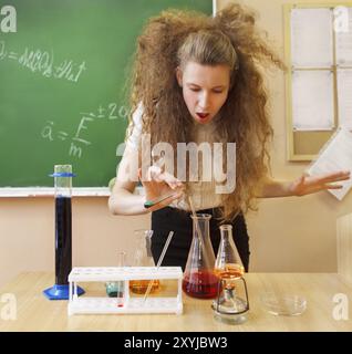 Ragazza che lavora nel laboratorio di chimica con formula liquida in aula Foto Stock