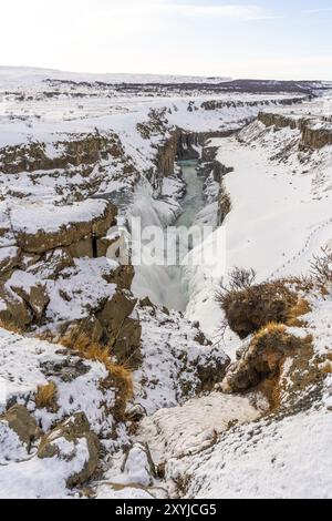 Splendida cascata innevata di Gullfoss nel freddo inverno islandese senza persone, foto verticale Foto Stock