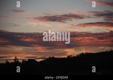 Nuvole rosse illuminate dal sole al tramonto Foto Stock