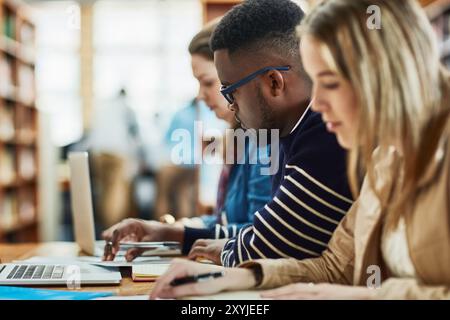 Notebook, appunti e amici che studiano in biblioteca per l'istruzione, la conoscenza o la preparazione ai test all'università. Studenti universitari, uomo e imparare Foto Stock