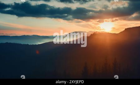 Il sole tramonta proietta una luce calda e lunghe ombre sulle vette e le valli dei carpazi, creando una scena serena e maestosa Foto Stock