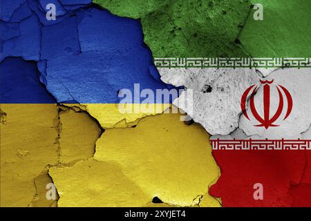 Bandiere di Ucraina e Iran dipinte su un muro incrinato Foto Stock