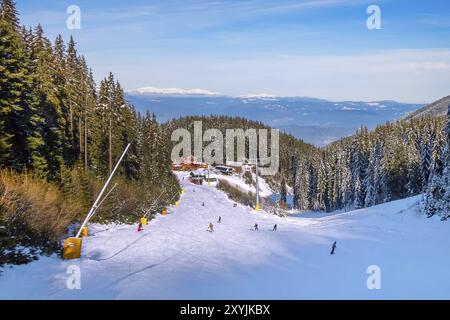 Bansko, Bulgaria ski resort vista panoramica con picchi di montagna, alberi di pino, sulle piste da sci, ristoranti e impianti di risalita Foto Stock