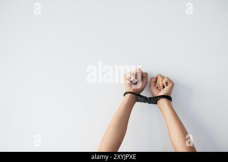 Mani, persone e legate con manette in studio per la sicurezza, l'arresto di prigionieri e ostaggi criminali di lotta. Polso, prigionia e limitato con Foto Stock