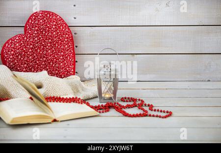 Natale ancora vita con la lanterna, cuscino, libro e perle di rosso su sfondo di legno Foto Stock