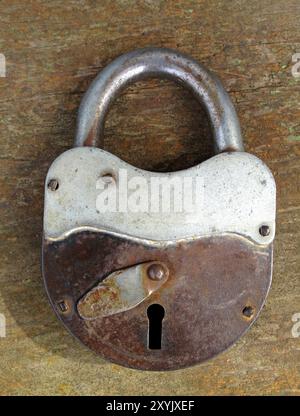 Vecchio lucchetto arrugginito su sfondo di legno Foto Stock