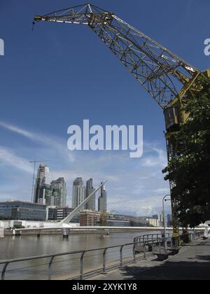 Un vecchio, restaurato gru presso il bacino di Puerto Madero, Buenas Aires, con la moderna passerella girevole e moderni edifici Foto Stock