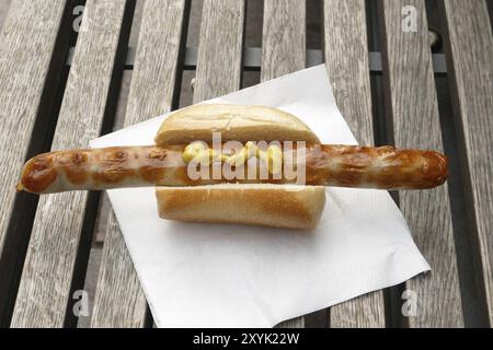 Salsiccia fritta con pane o hot dog su tovagliolo di carta alla griglia in un mercatino di natale Foto Stock