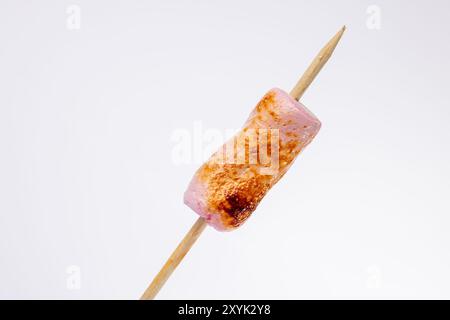 Questa immagine orizzontale mostra una vista ravvicinata degli spiedini con marshmallow tostati. L'attenzione è sulla consistenza dei marshmallow, prominentemente dis Foto Stock