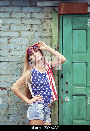 Ragazza bionda tiene le mani sul suo indossando occhiali closses in american stile retrò Foto Stock