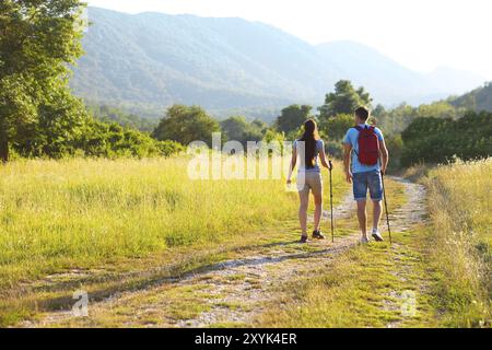 Donna e uomo trekking in montagna con zaino al tramonto Foto Stock