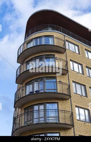 Edificio di appartamenti in mattoni con finestre d'angolo retro arrotondate e balconi Foto Stock