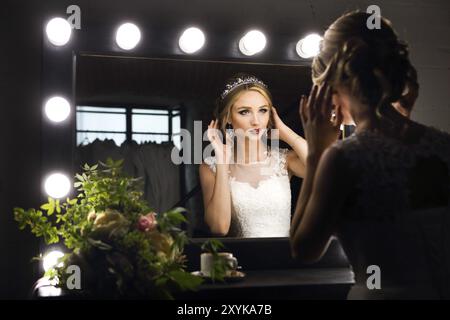 Ritratto di giovane sposa vicino a specchio vista posteriore. Brides mattina Foto Stock