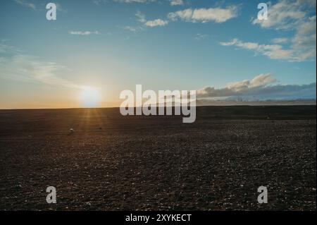 Deserto di Solheimasandur in Islanda, con montagne innevate al tramonto. Foto Stock