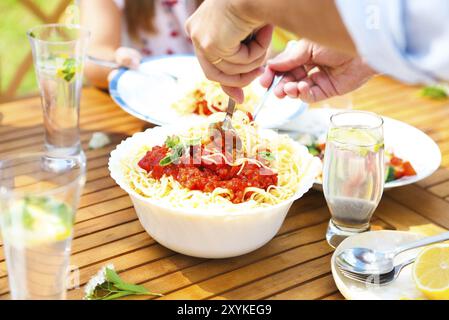 Cena in famiglia varietà di piatti italiani sul tavolo di legno in giardino Foto Stock