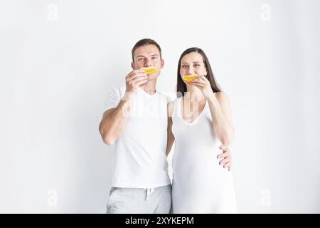 Giovani incinte sorridente bella donna e uomo con frutta Foto Stock