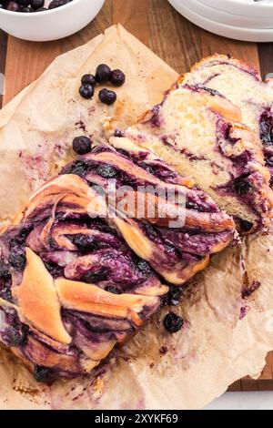 Babka di formaggio cremoso ai mirtilli appena tagliata su carta pergamena Foto Stock