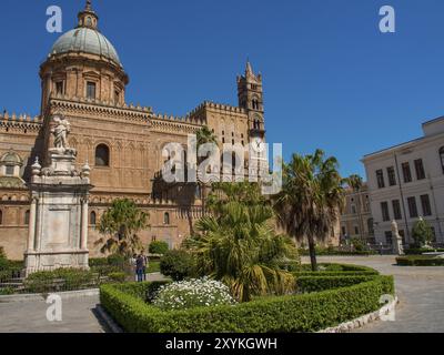 Grande cattedrale con cupola e elementi gotici, circondata da giardini e palme, sotto un cielo limpido, palermo, sicilia, mediterraneo, italia Foto Stock