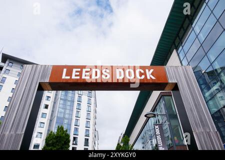 Leeds Inghilterra: 3 giugno 2024: Ingresso al molo di Leeds. Un grande cartello con la scritta Leeds Dock si trova sopra una strada moderna di Leeds Foto Stock