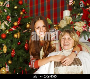 Ritratto di una nonna e teen nipote vicino all'albero di Natale di essere felice e gioiosa Foto Stock