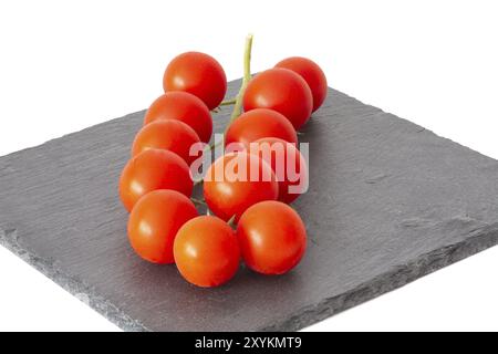 Pomodori ciliegini freschi su un piatto di ardesia nera Foto Stock