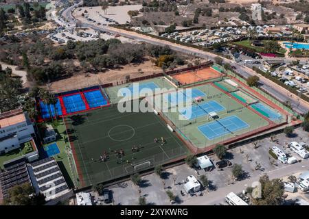 Foto aerea del drone della città di Benidorm in Spagna che mostra un grande campo da calcio e campi da tennis accanto a un parco per roulotte in una giornata calda Foto Stock