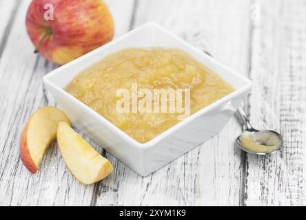 Salsa di mele fatta in casa (messa a fuoco selettiva, foto ravvicinata) su sfondo vintage con frutta fresca Foto Stock